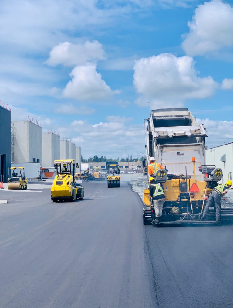 working on a warehouse, burnaby blacktop crew and trucks in action