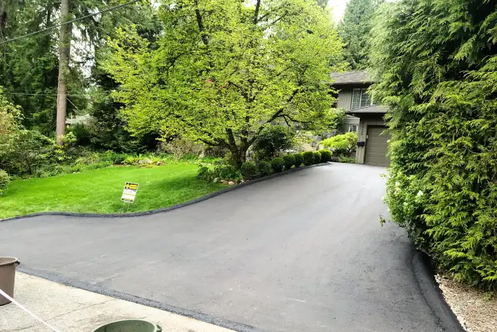 driveway in Vancouver freshly paved and a sign of Burnaby blacktop on the left
