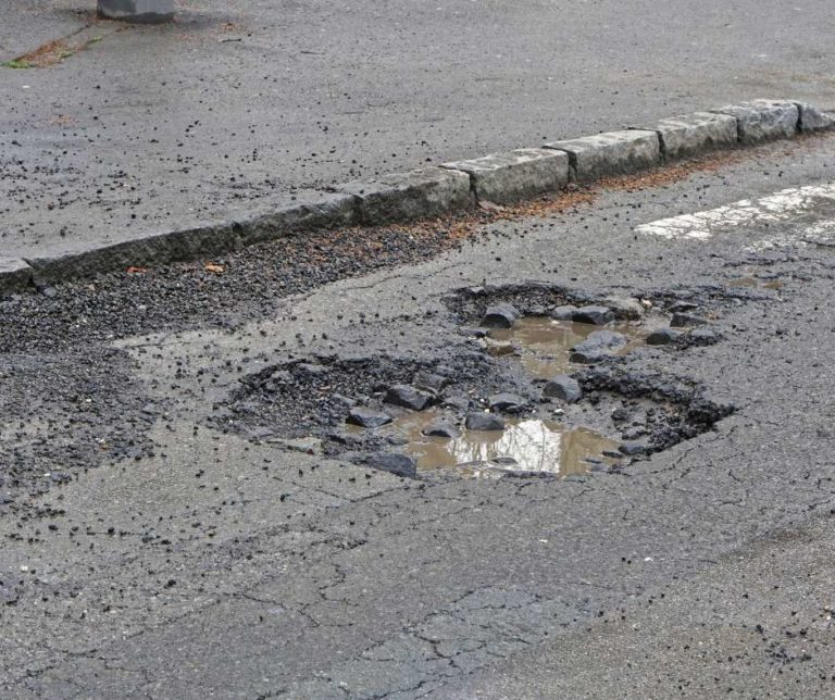 pot hole in road with accumulated water