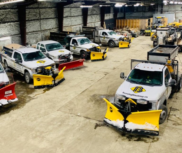 snow plows from Burnaby Blacktop line up in garage