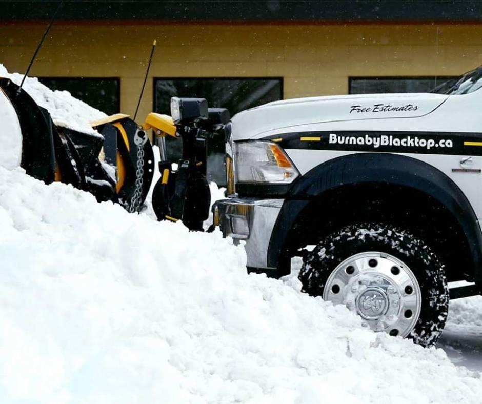 snow removal plow from Burnaby Blacktop plowing snow in a parking lot