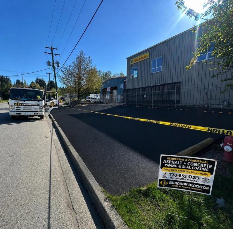 burnaby blacktop truck on the side of the freshly finished seal coated parking lot from Action Glass facility